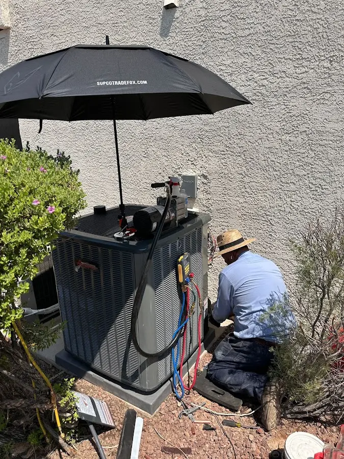 HVAC technician performing outdoor AC maintenance in Santa Teresa