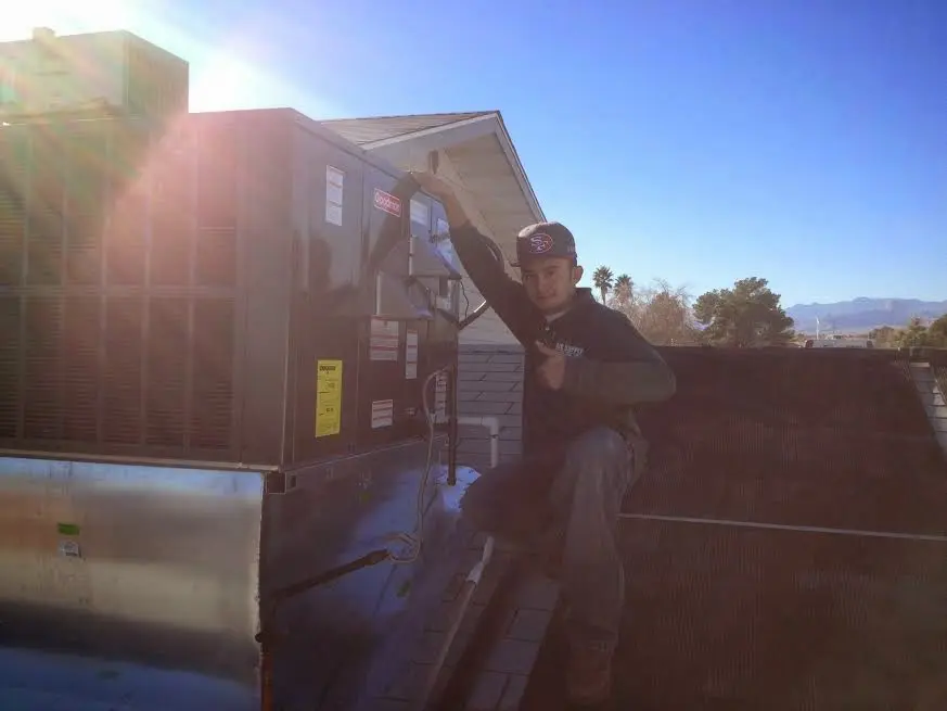 HVAC technician performing Heat Pump Repair on a rooftop unit in Santa Teresa